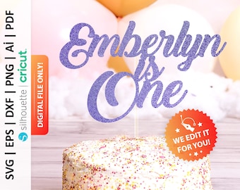May include: Purple glitter cake topper with the text "Emberlyn is One" in a cursive font. The topper is on top of a white cake with pink and yellow sprinkles.