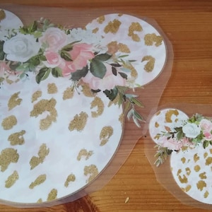 May include: Two white and gold leopard print iron-on transfers in the shape of Mickey Mouse ears with a floral design.