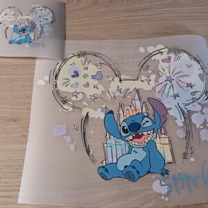 May include: A blue cartoon character, Stitch, winks and smiles in a whimsical illustration. The design includes a castle, stars, and the word "Stitch" in light blue. The image is on a translucent sheet.