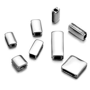 Könnte beinhalten: Ein Satz von acht silbernen Metall-Abstandsperlen für die Schmuckherstellung. Die Perlen sind rechteckig und haben eine glatte, polierte Oberfläche.