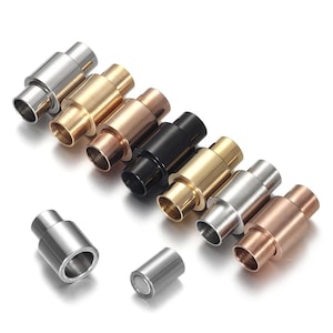 May include: An assortment of magnetic clasps in different metallic finishes: silver, gold, rose gold, and black. These cylindrical clasps are for jewellery making and have a secure magnetic closure.