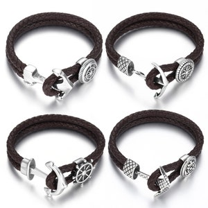 May include: Four brown leather bracelets with nautical-themed charms. Each bracelet features a braided leather band and a silver-colored clasp. The charms include anchors, ship wheels, and compass designs, creating a maritime aesthetic.
