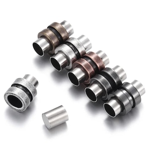 May include: An assortment of magnetic jewellery clasps in bronze, silver, copper, and gunmetal finishes. The cylindrical clasps feature a magnetic closure, suitable for necklaces and bracelets. Measurements are in centimetres.