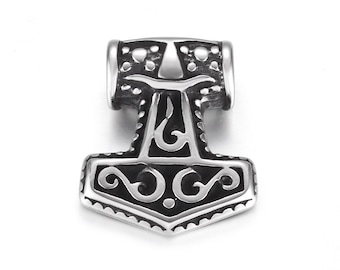 May include: A silver pendant shaped like Thor's hammer, Mjolnir. The pendant has detailed engravings and a polished surface. The hammerhead is rectangular with rounded edges and a detailed handle. A Viking-themed accessory.