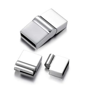 May include: Three shiny, silver-coloured magnetic clasps are shown. The clasps are rectangular with rounded edges and a magnetic closure. They are designed for jewellery making or crafts.