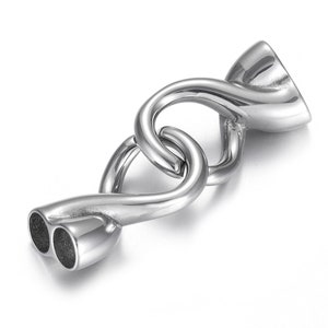 Könnte beinhalten: Silberfarbener Metallverschluss mit einem gedrehten Design. Der Verschluss hat zwei Schlaufen an einem Ende und eine einzelne Schlaufe am anderen Ende.