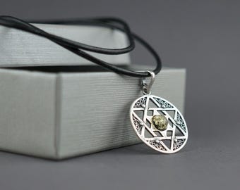 May include: A silver pendant necklace with a black leather cord. The pendant features a Star of David design with an amber-colored stone in the center. The necklace is displayed on a gray box against a gray background.