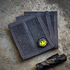 May include: A set of six black fabric pouches with a yellow smiley face patch. The pouches have multiple compartments and are designed for carrying small items.
