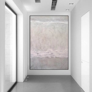 May include: A large abstract painting in shades of white, gray, and light pink hangs on a white wall in a modern hallway. The painting has a textured surface and appears to depict a landscape or seascape.