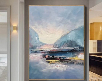 May include: Abstract landscape painting with blue, white, and pink hues. The painting depicts a mountain range with a body of water in the foreground. The sky is a light blue with white clouds.