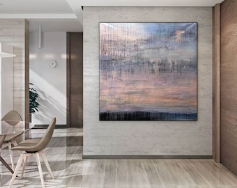 May include: Large abstract painting with a black frame, featuring a blend of blue, gray, and peach hues. Vertical brushstrokes create a textured effect, evoking a sense of depth and movement. The artwork hangs on a light gray wall in a modern interior.