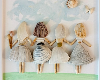 May include: A framed wall art piece featuring four figures crafted from various seashells. The figures stand in a row against a painted background of a light blue sky and green grass. Each figure has a unique shell-based dress and hairstyle.