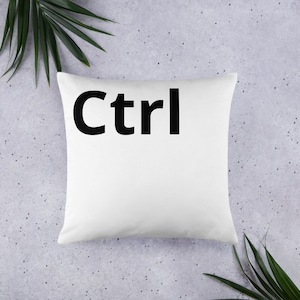 Könnte beinhalten: Weißes Kissen mit dem Wort "Ctrl" in Schwarz gedruckt.