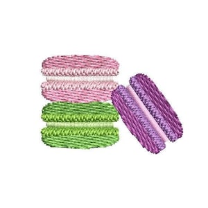 Può includere: Tre macarons, uno impilato sull'altro, in rosa, verde e viola.