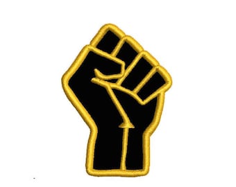 May include: Black fist raised in the air, outlined in gold. The fist is a symbol of strength and solidarity.