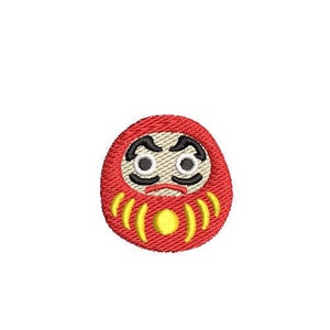 May include: Red and yellow daruma doll with a black and white face. The doll has a serious expression with furrowed brows and closed eyes.