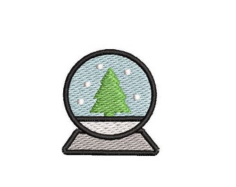 May include: A snow globe with a green Christmas tree inside. The globe is filled with white snow and has a blue background.