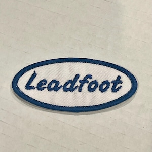 May include: White oval patch with a blue border and the text "Leadfoot" embroidered in blue.
