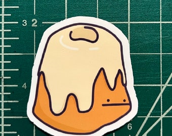 May include: A cartoon illustration of a brown cake with white frosting. The cake has a cute, cartoon face with two black eyes and a small mouth.