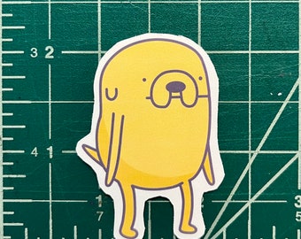May include: A yellow cartoon dog with a purple nose and eyes. The dog has a simple design and is standing on two legs.