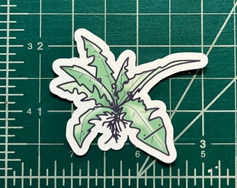 May include: A green and white sticker of a stylized dandelion plant with a long stem and multiple leaves.