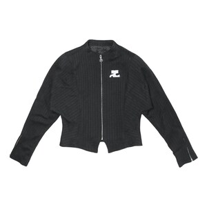 May include: Black zip-up jacket with a ribbed texture and a small white logo on the chest. The jacket has long sleeves with zippers at the cuffs. The collar is a stand-up style.