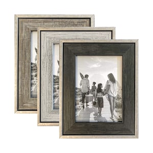 May include: Set of three rustic wood picture frames with a silver trim. The frames are nested together and feature a black and white photo of a family walking on a boardwalk.