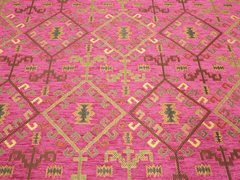 May include: Pink fabric with a geometric pattern in brown, gold, and green. The pattern is a repeating diamond shape with intricate details.
