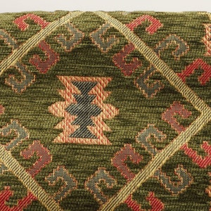 May include: Green throw pillow with a geometric pattern in red, gold, and black. The pattern is woven into the fabric.