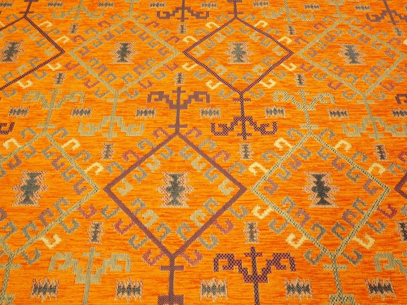 May include: Orange rug with a geometric pattern in shades of brown, green, and red.