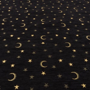 Può includere: Un tappeto nero con un motivo ripetitivo di stelle dorate e lune crescenti.