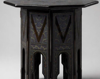 Mesa auxiliar plegable octogonal birmana vintage con tablero sostenido por una base arqueada con paneles.