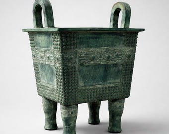 Caldero rectangular chino de bronce con motivo de máscara de animal.
