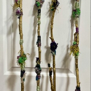 May include: Four decorative sticks with gold paint and various colorful fabric, beads, and yarn embellishments.
