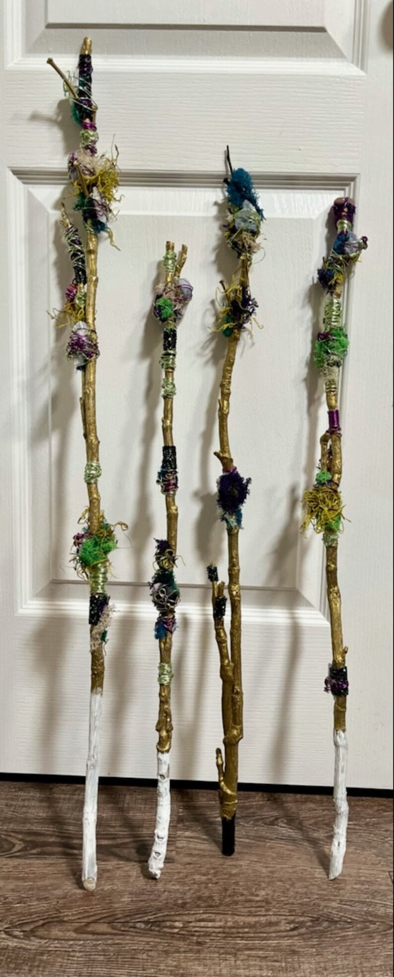 May include: Four decorative sticks with gold paint and various colorful fabric, beads, and yarn embellishments.