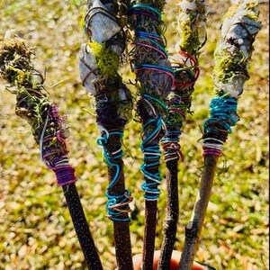 May include: Five wooden wands wrapped in colorful wire and adorned with crystals and moss.