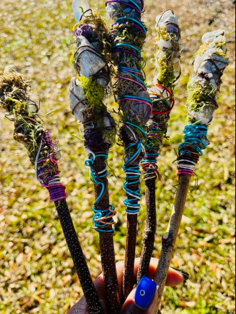 May include: Five wooden wands wrapped in colorful wire and adorned with crystals and moss.