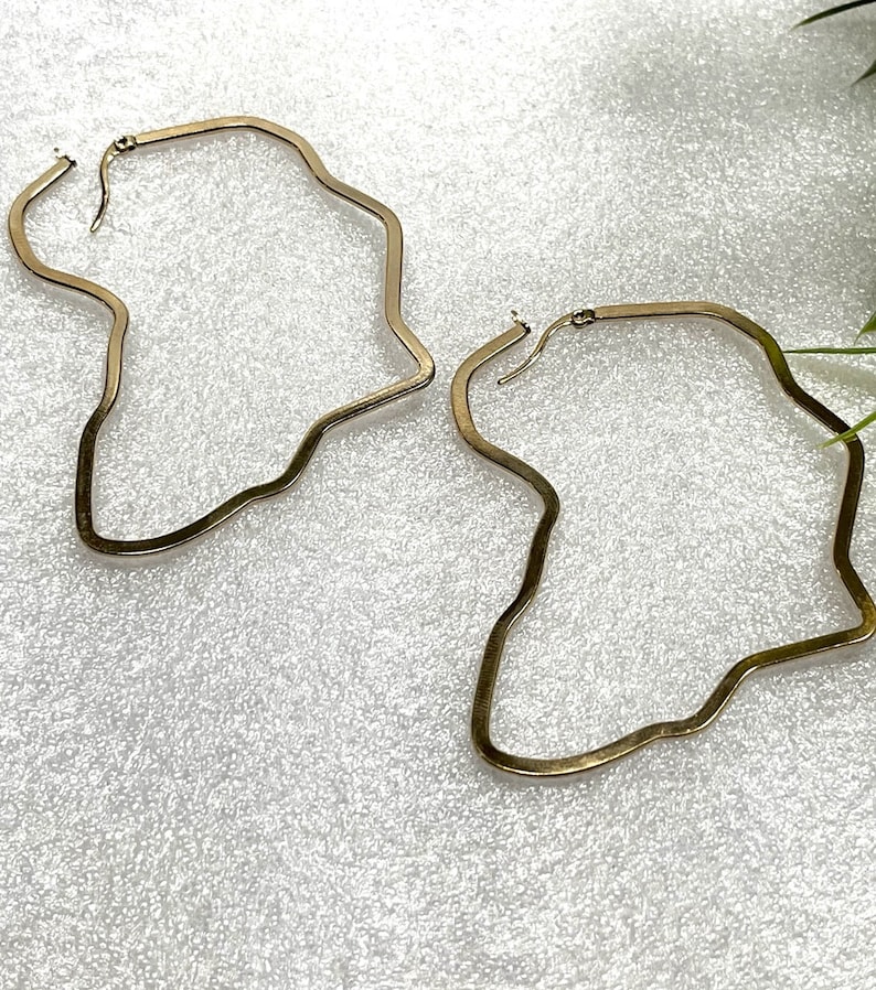 Op de afbeelding: Een paar gouden oorringen met een onregelmatige, golvende vorm.