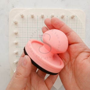 Puede incluir: Un sello de goma rosa y negro con el texto "CRAP FOR YOU EASY" en el lateral. El sello está siendo sostenido en la mano de una persona.