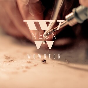May include: Close-up of a soldering iron in use, with smoke rising. The image features the text "NEON" and "WOWNEON" in a stylized font. The background is a warm, sepia tone.