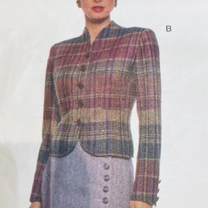 Könnte beinhalten: Vintage-Jacke mit Karomuster in Lila, Blau und Gold, kombiniert mit einem grauen Rock. Die Jacke hat einen Stehkragen und einen Knopfverschluss. Der Rock hat eine Reihe dekorativer Knöpfe. Ein klassisches Ensemble.