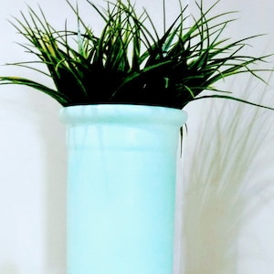 May include: A set of three ceramic mugs with a speckled, matte finish. The mugs are in shades of cream, light gray, and dark gray. Each mug has a simple, minimalist design and a rounded handle.