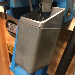 May include: A gray metal reloading tray with a blue base. The tray is designed to hold bullets or other small objects.
