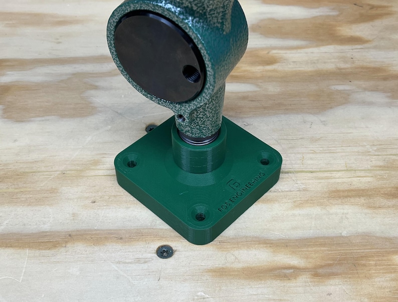 May include: A green metal vice with a black base and a square base with the text "FOS ENGINEERING" on it.