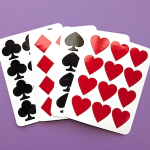 May include: Four playing cards with different suits. The first card has a row of black clubs, the second card has red diamonds, the third card has black spades, and the fourth card has red hearts.