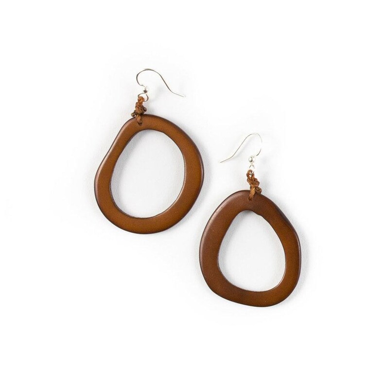 May include: A pair of brown leather earrings with a unique, organic shape. The earrings are made of a natural material and have a simple, elegant design.