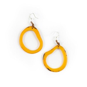 May include: A pair of yellow, organic-shaped earrings with a brown leather cord and silver hooks.