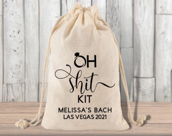 May include: A white cotton drawstring bag with the text "OH shit KIT" and a ring emoji. The bag also has the text "Melissa's Bach Las Vegas 2021".