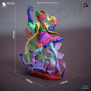 Op de afbeelding: Een kleurrijk fantasiebeeldje, 27,5 cm hoog, met een figuur in een gelaagde rok en een gele jas, die een schedel vasthoudt. De basis omvat twee figuren en een grafsteen. Het beeldje is 17,8 cm breed en 17,9 cm diep.