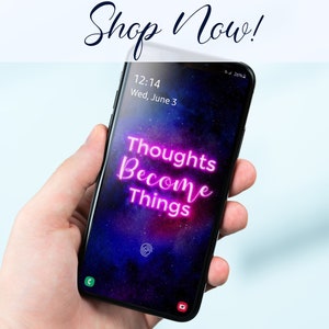 Puede incluir: Un tel&eacute;fono inteligente con un fondo de galaxia y el texto "Thoughts Become Things" en letras de ne&oacute;n rosa.